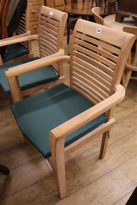 A set of four teak garden armchairs, with green squab cushions